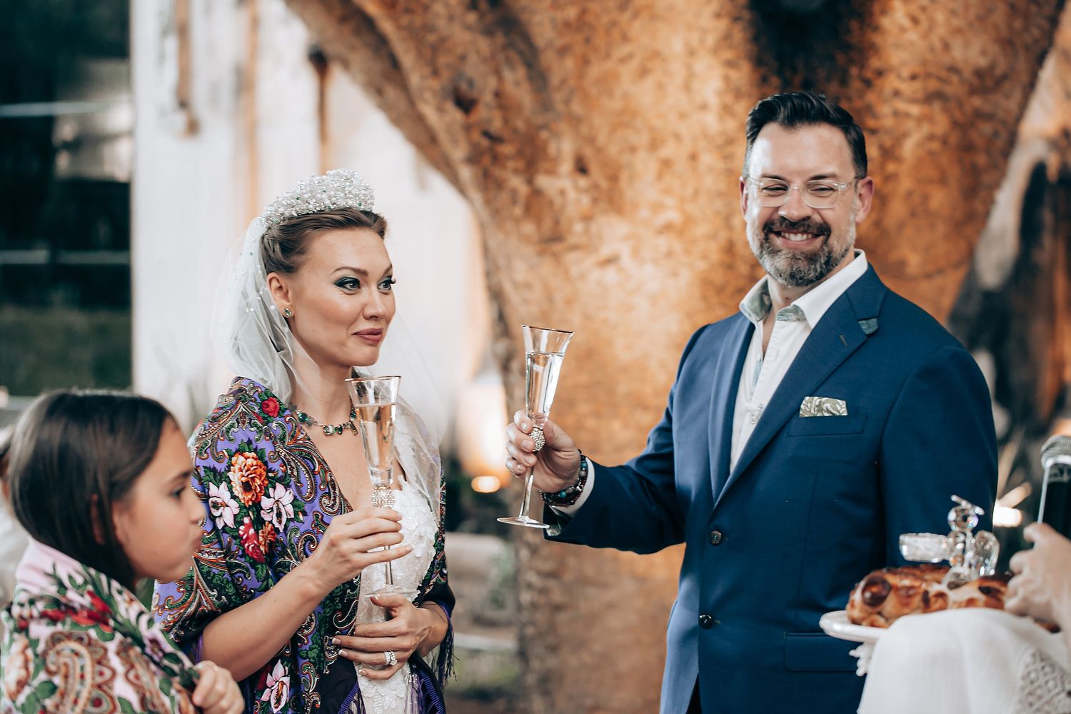 A wedding celebration at a rustic stone venue with guests enjoying drinks and conversation during a reception.