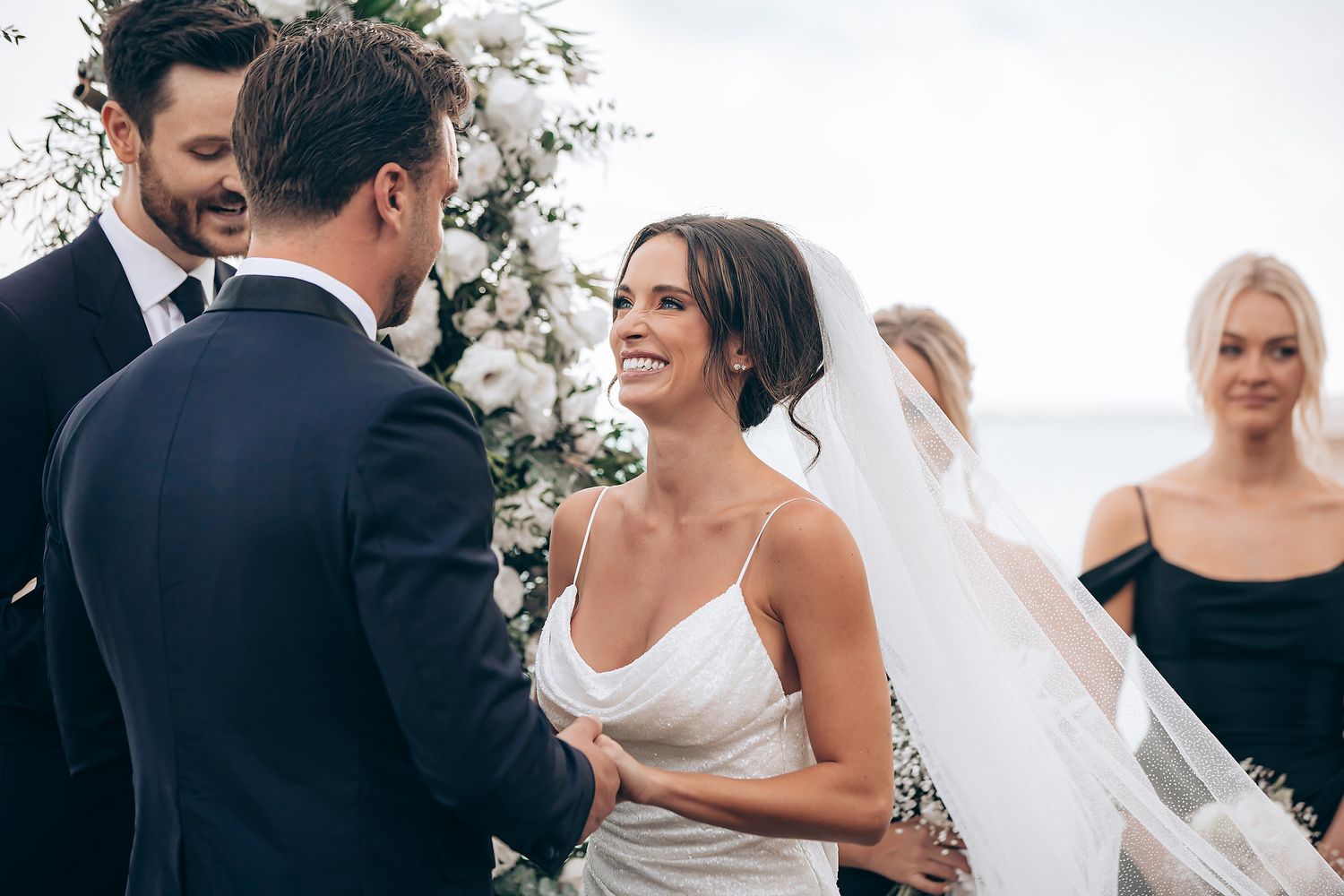 Wedding party celebrates joyfully outdoors during a summer ceremony.