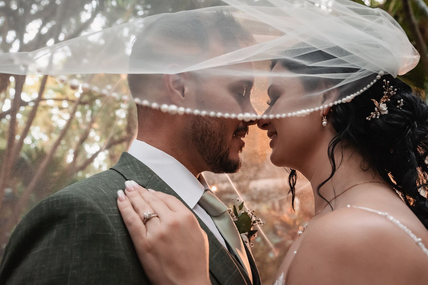 Close-up shot of wedding veil flowing in the breeze during an intimate moment.
