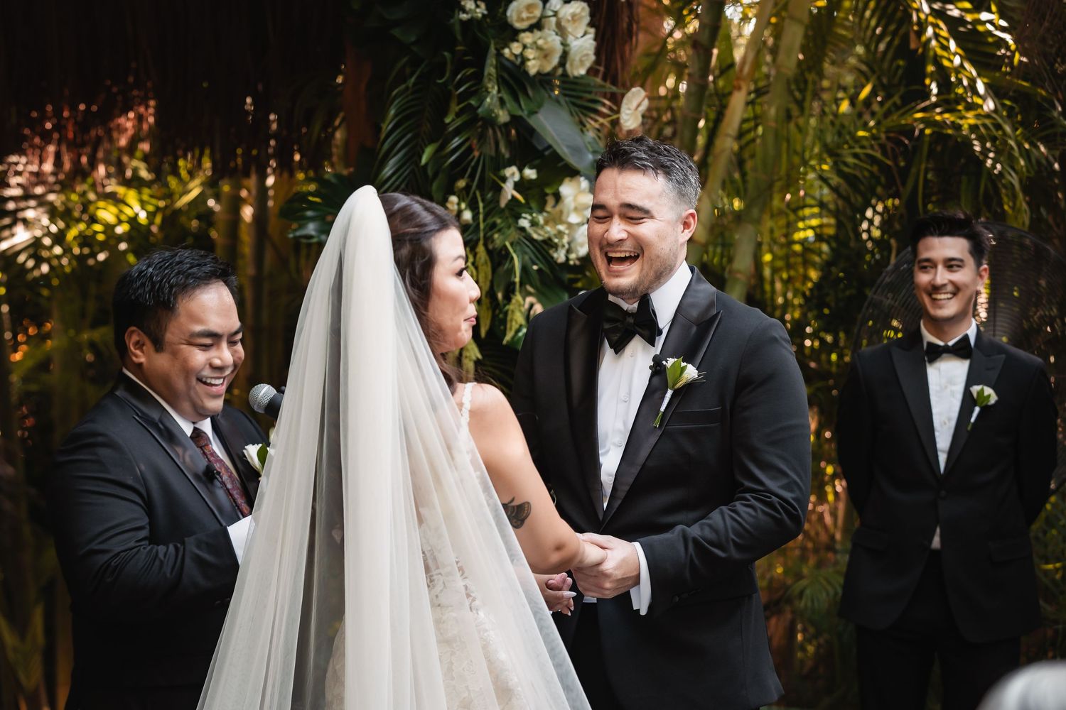 Wedding party members in formal attire gather for outdoor celebration photos.
