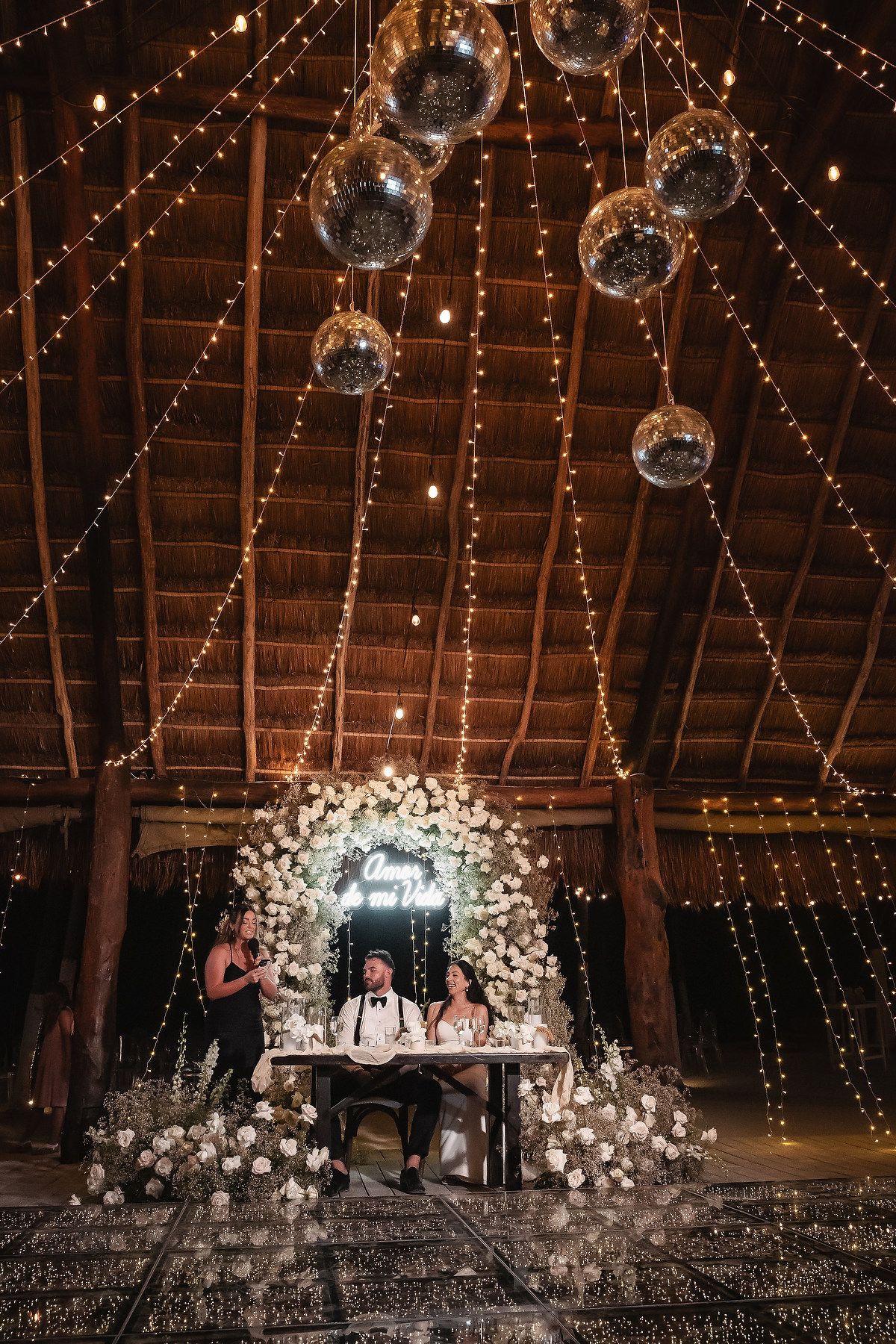 Elegant wedding reception space with disco balls and string lights creating a magical ambiance.