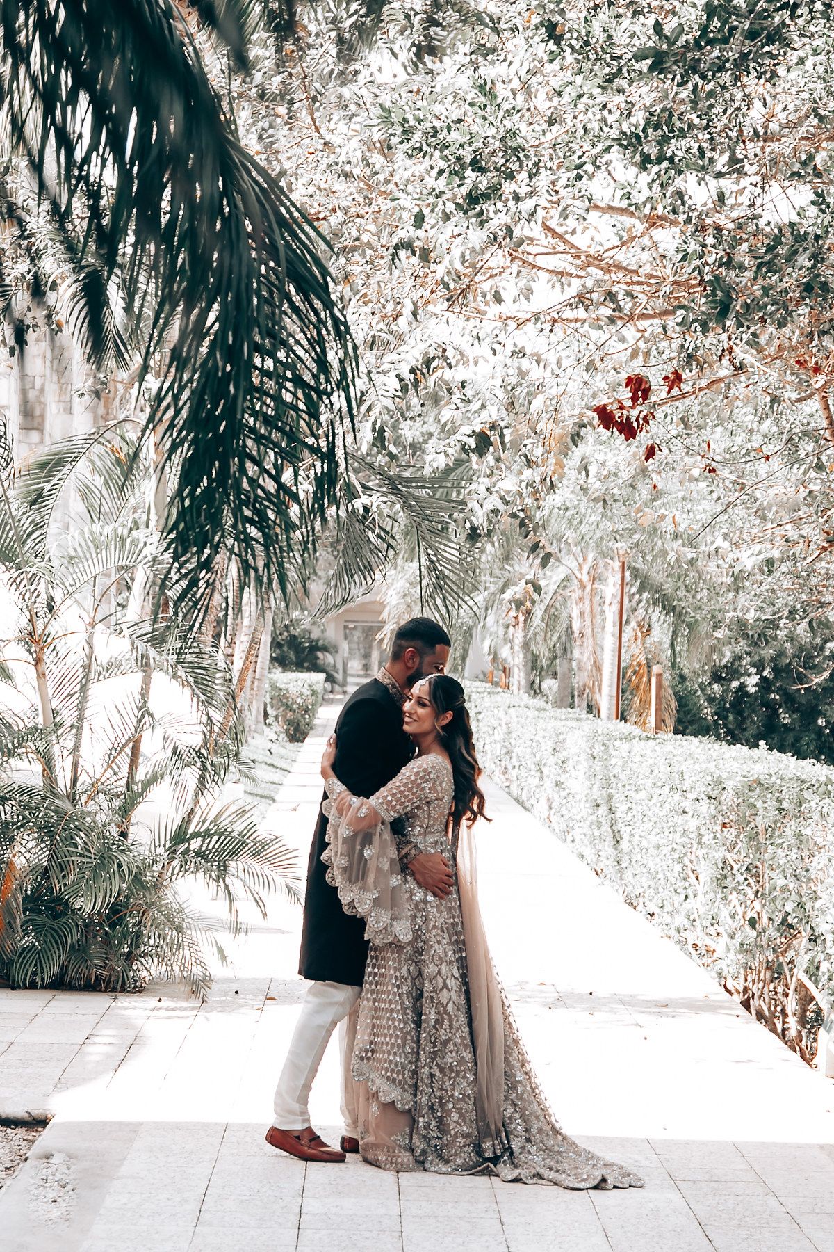 Romantic dance poses captured in a dreamy palm garden setting.