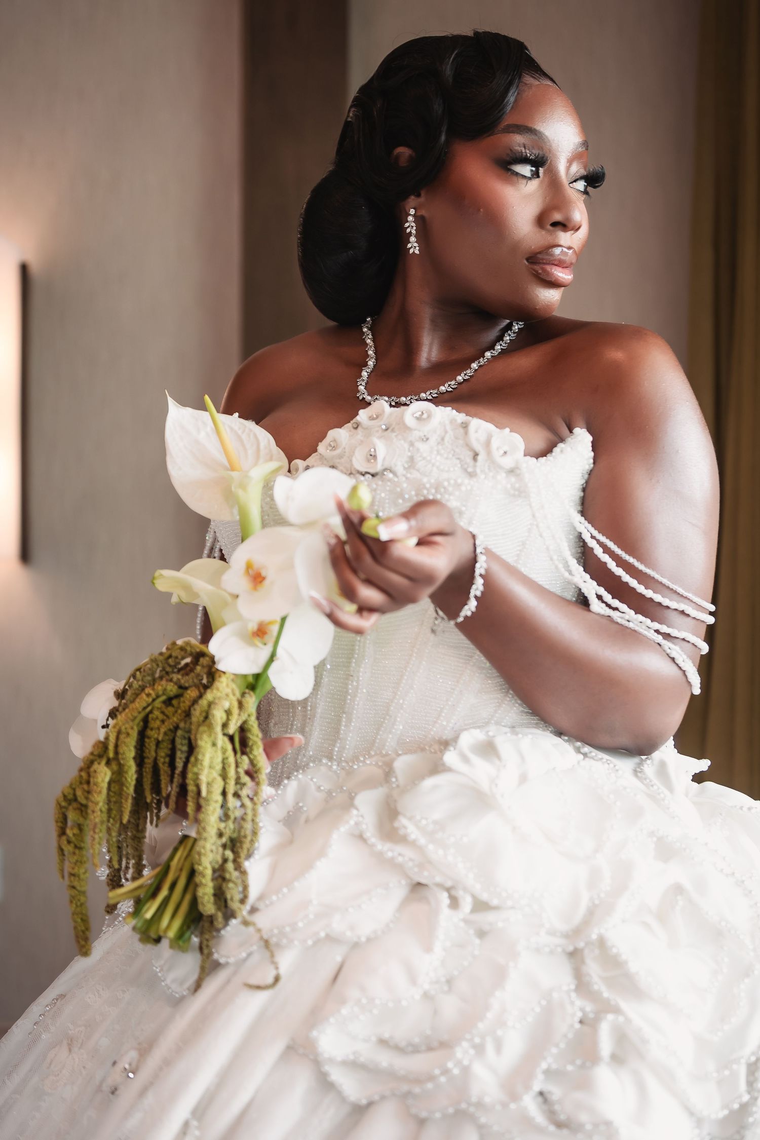 An elegant bridal portrait featuring white orchids and delicate jewelry details.