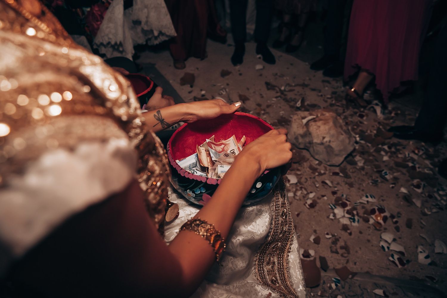 Dark and moody reception scene with dancing guests and scattered confetti.