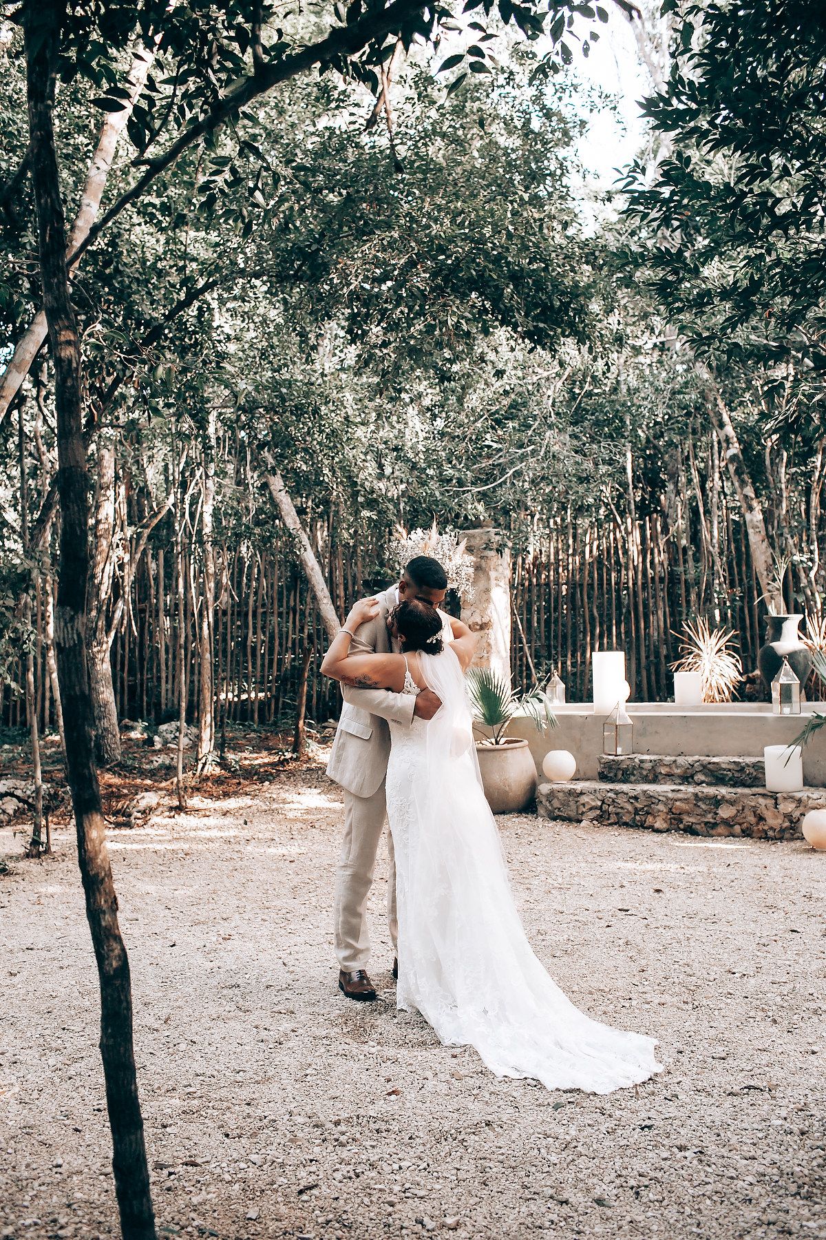 A wedding celebration in a forest clearing with white floral arrangements and decorative elements.