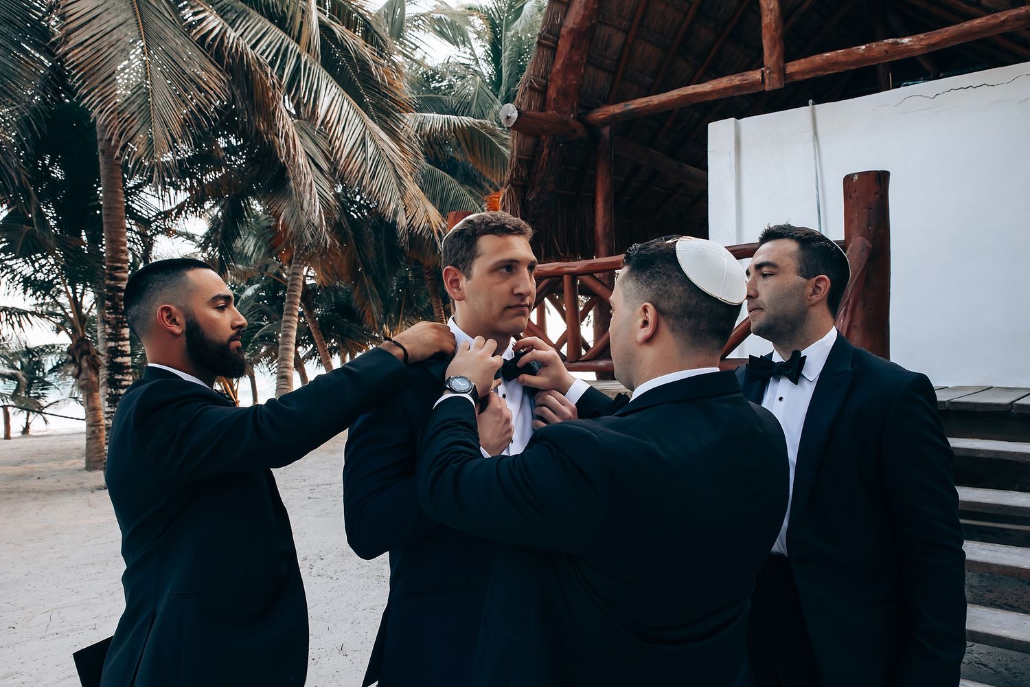 Wedding party celebrating outdoors with palm trees in the background.