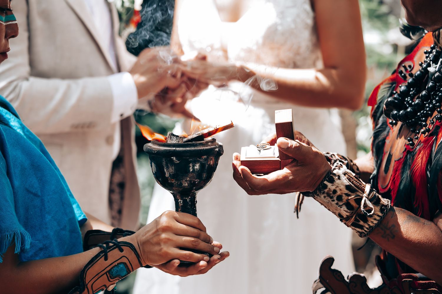 Wedding ceremony participants exchanging items during an outdoor forest celebration.