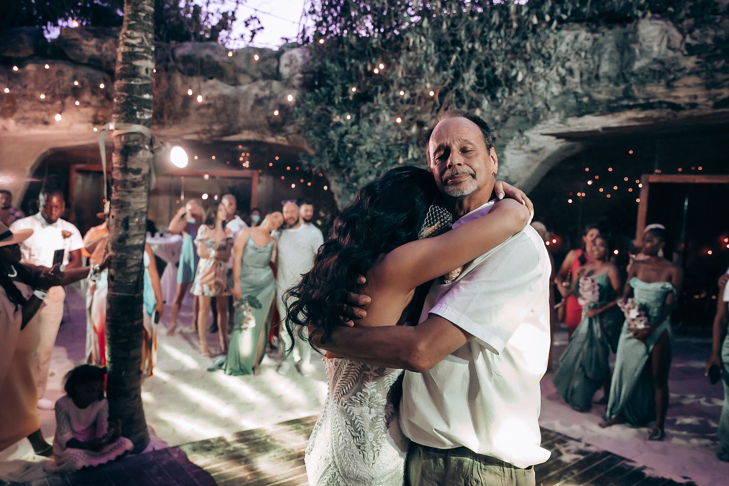 Wedding reception dance party with sparklers and lighting effects in cave venue.