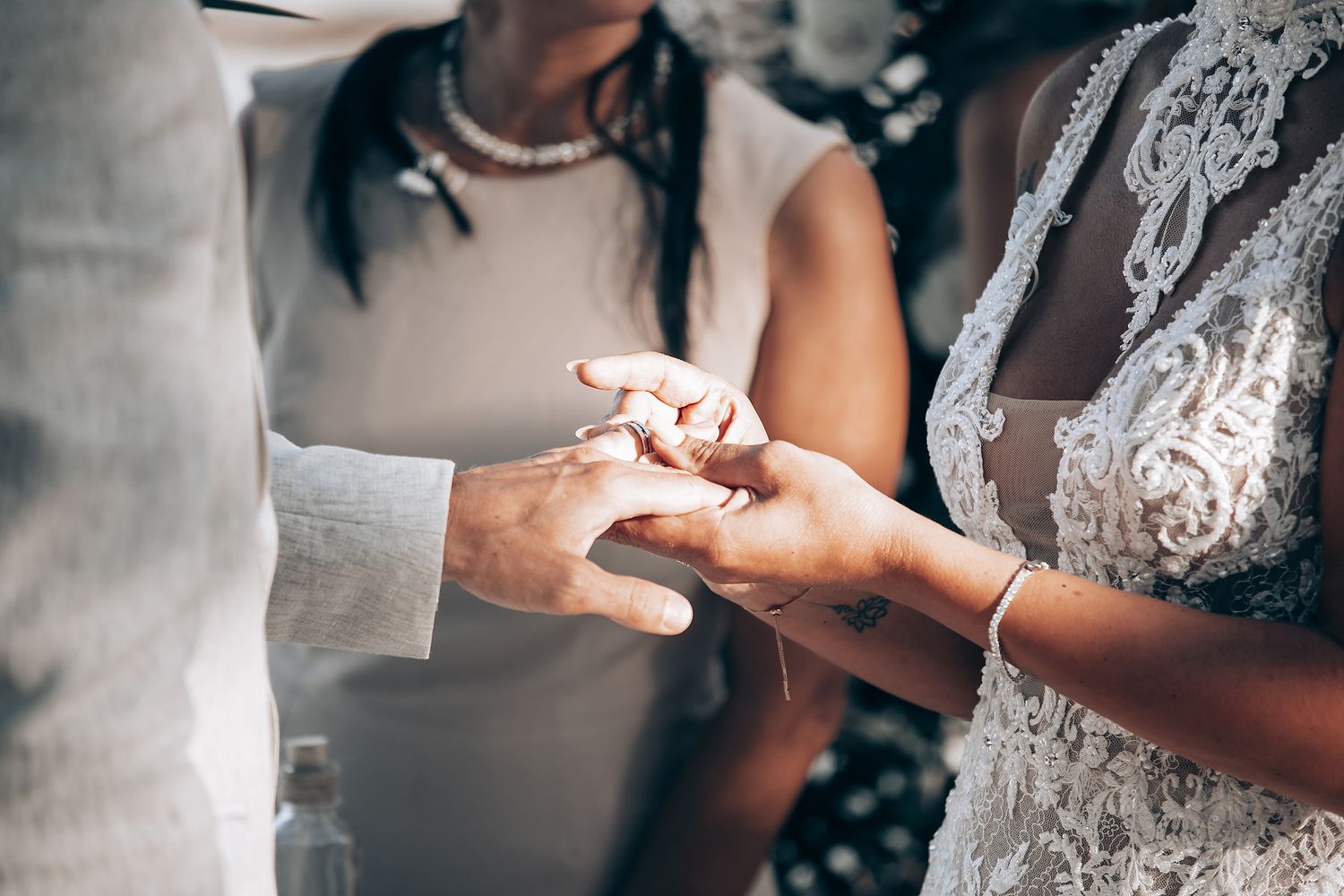 Wedding ring exchange during beach ceremony.
