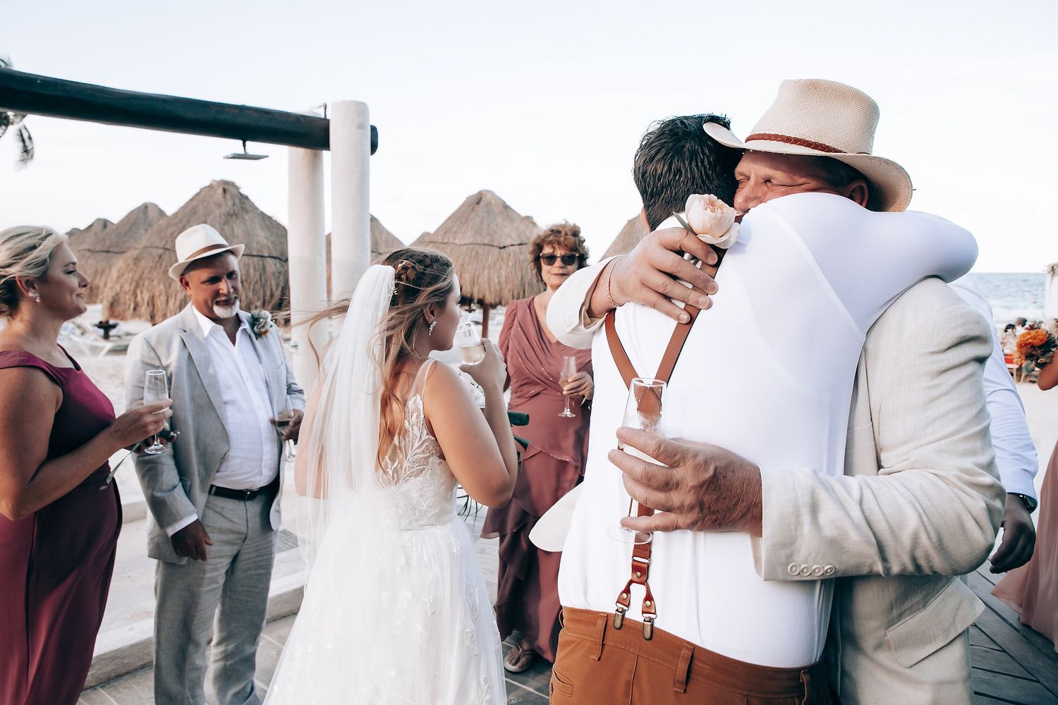 Wedding guests dancing and celebrating together at an outdoor reception with string lights overhead.