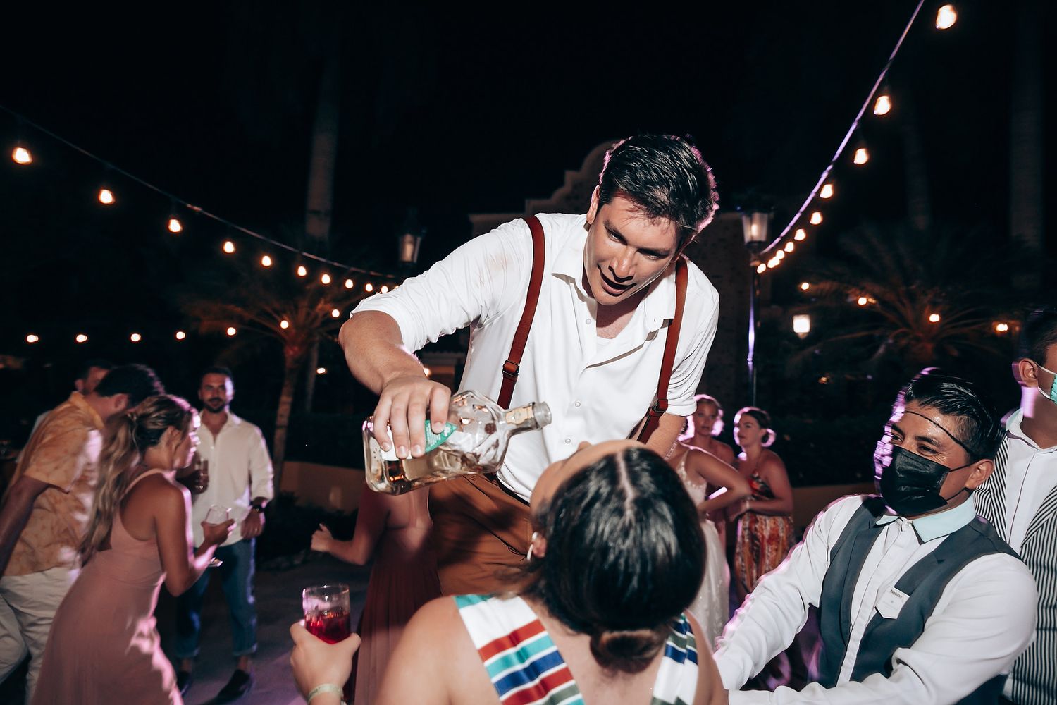 Wedding reception dance party with string lights creating festive atmosphere.