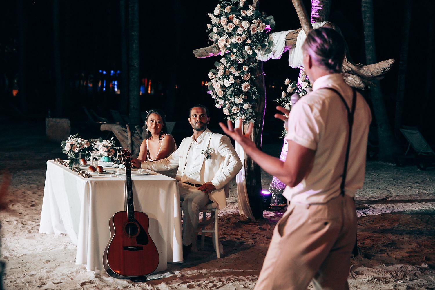 Wedding reception entertainment with acoustic guitar and string lights creating intimate atmosphere.