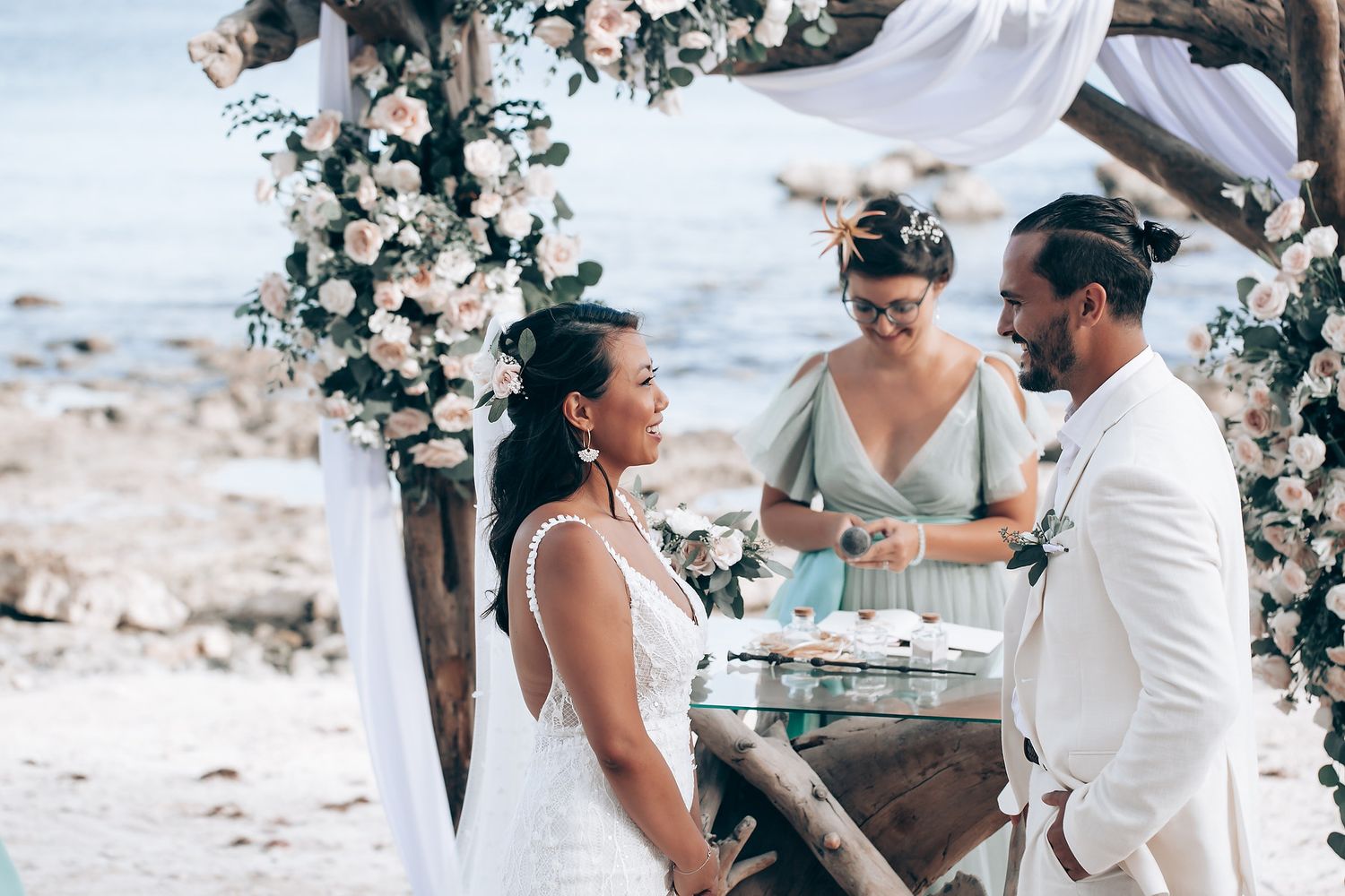 An intimate beach wedding ceremony with floral decorations and ocean views.