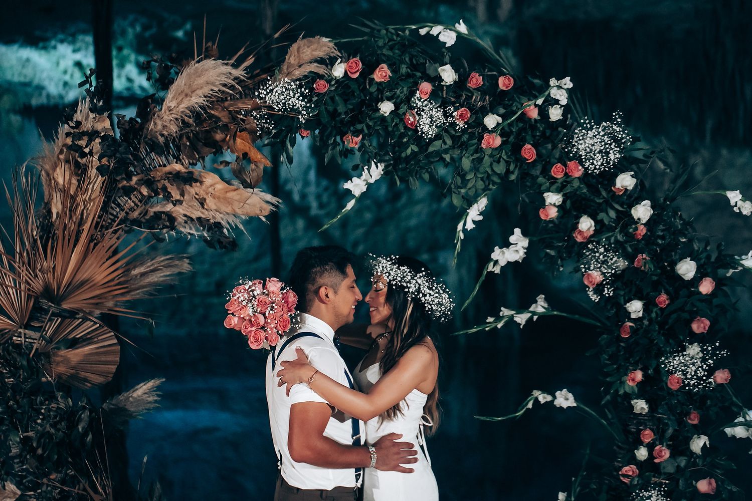 A romantic wedding ceremony setup with glowing lanterns and floral arrangements in an outdoor garden setting.