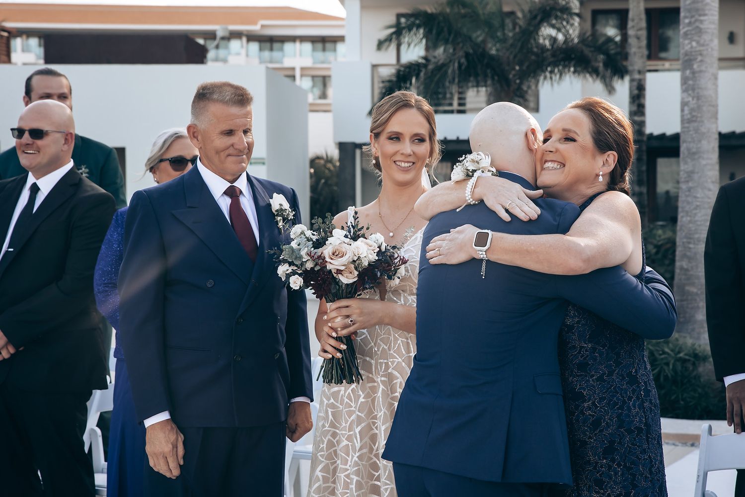 A group of people, including the bride and groom, celebrating at a wedding reception.
