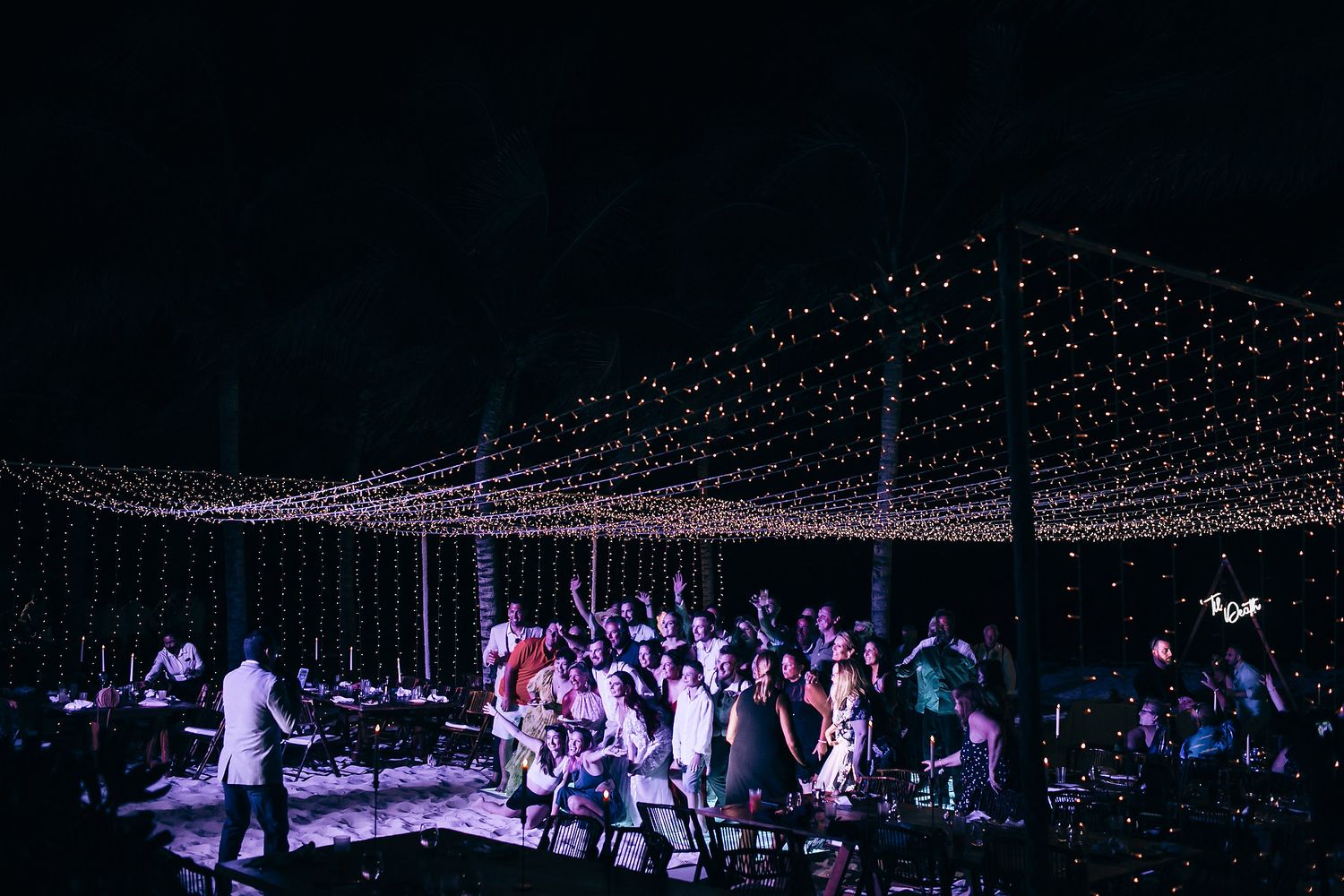 A large outdoor event space at night illuminated by thousands of twinkling string lights creating a magical canopy.