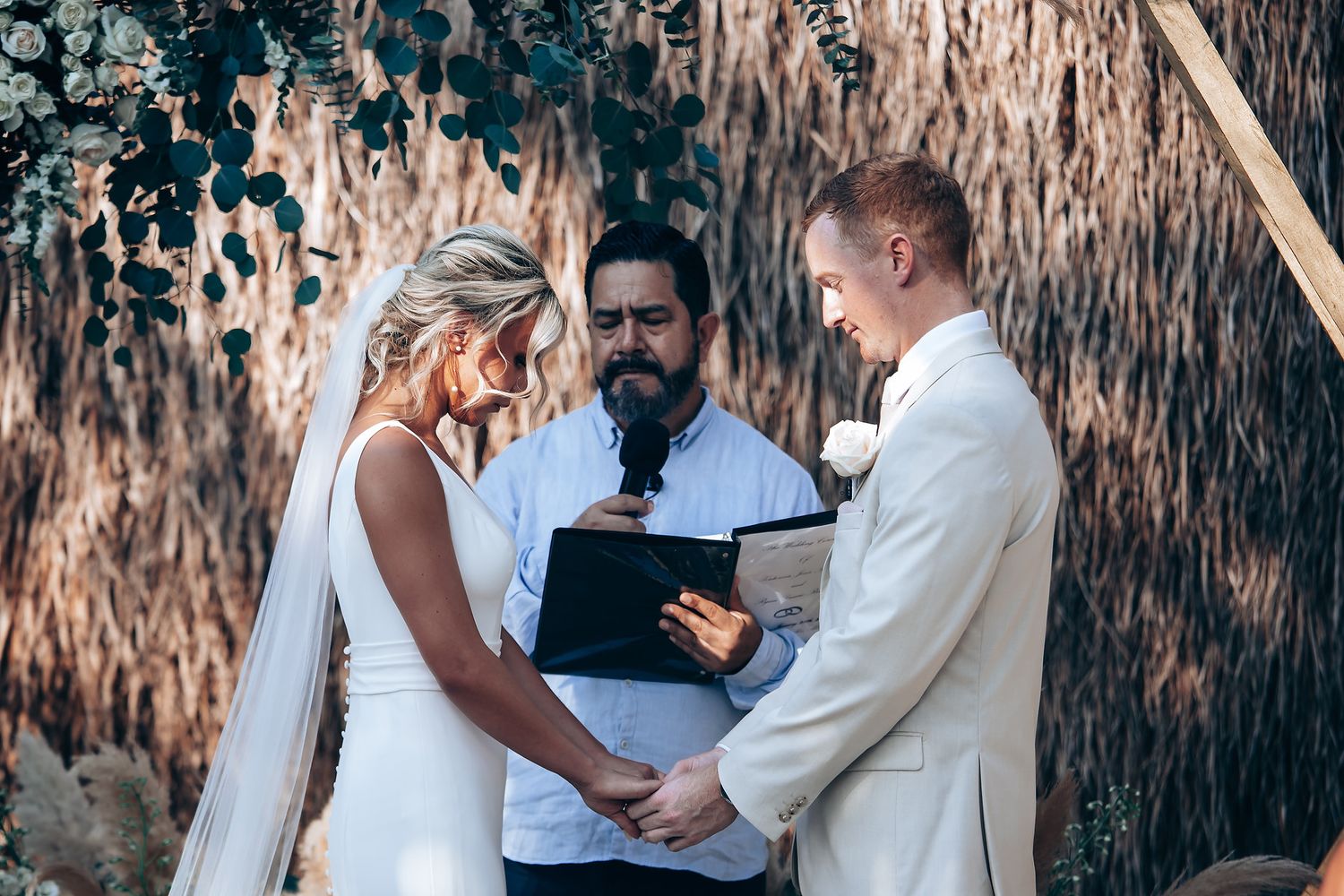 Wedding ceremony taking place in front of a natural backdrop with textured walls.
