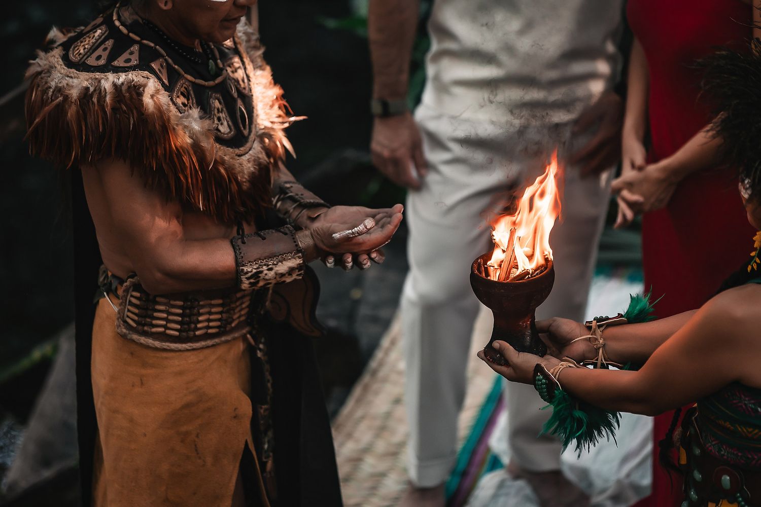 Traditional ceremony participants exchanging sacred objects in a mystical forest setting.
