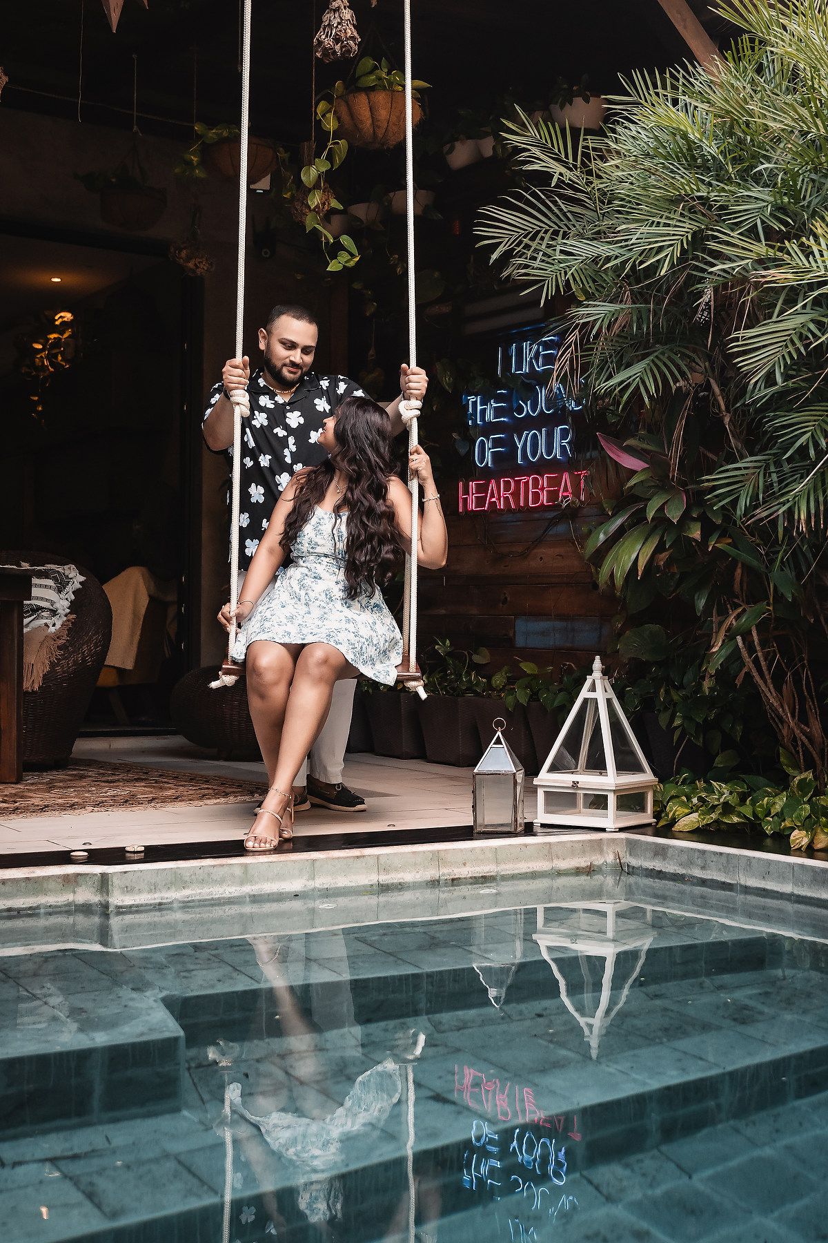 A romantic proposal sequence by a pool with neon signs in the background.