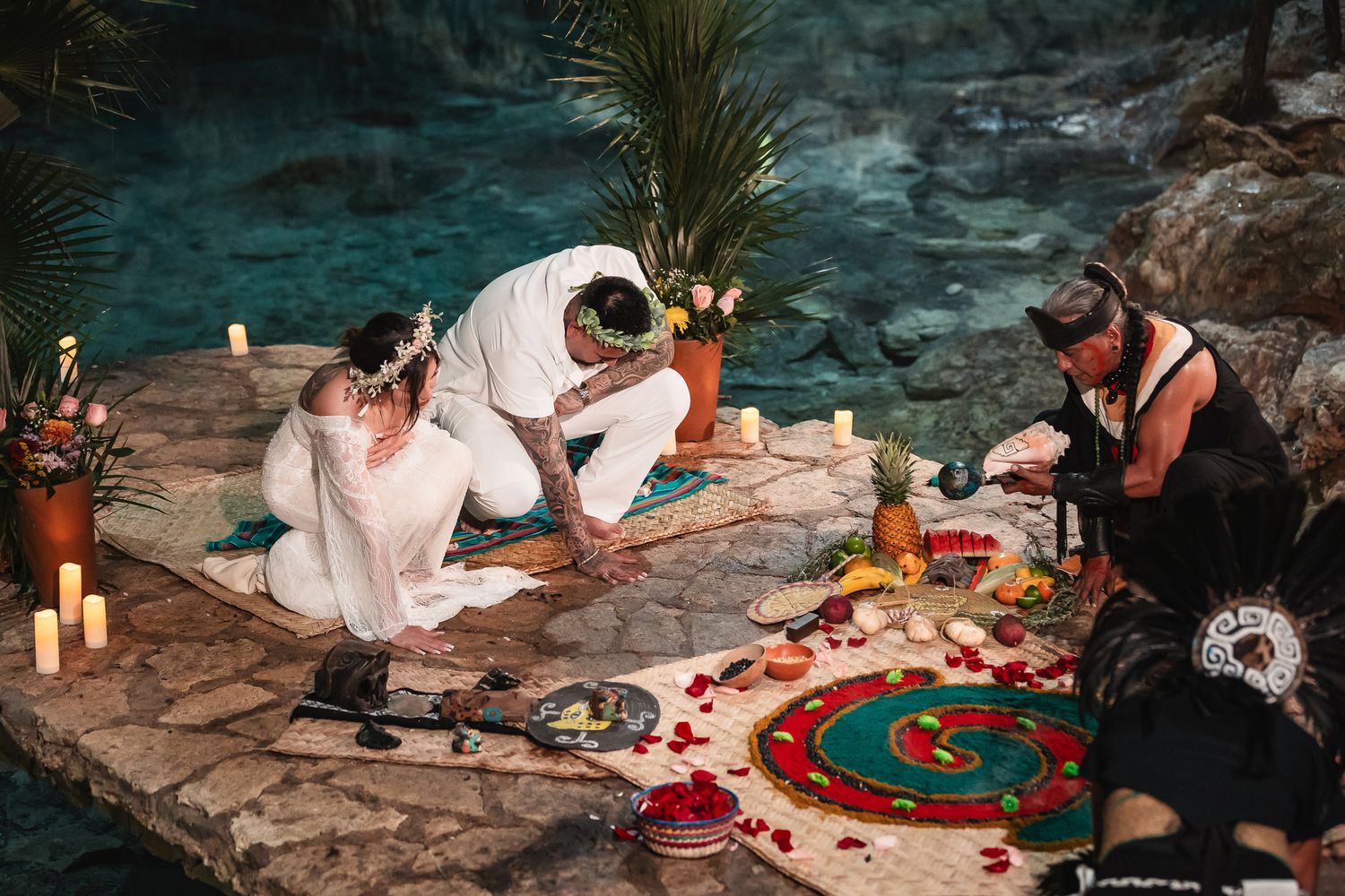 Cave dining experience with rose petals and candles creating romantic atmosphere.