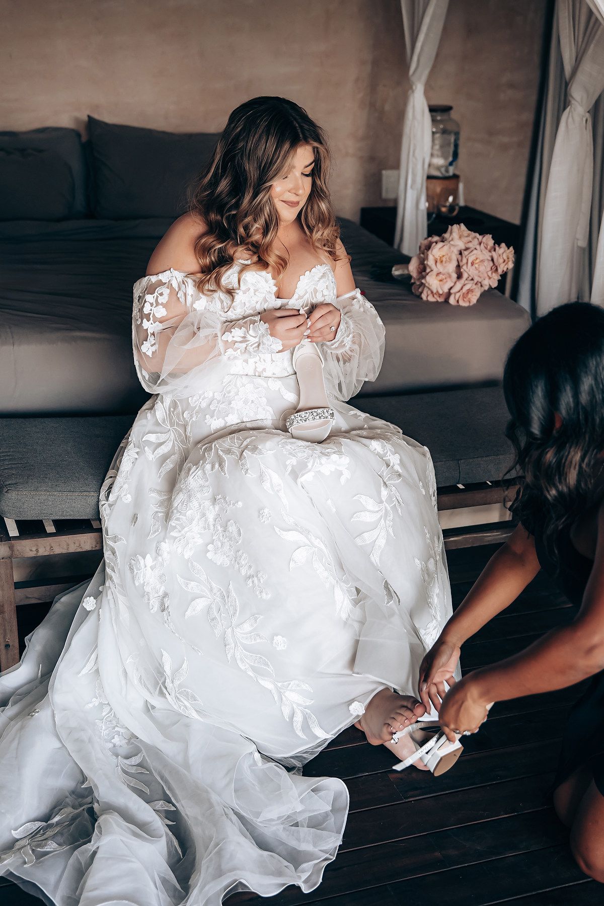 Wedding preparation scene showing the arrangement of a flowing white lace gown.