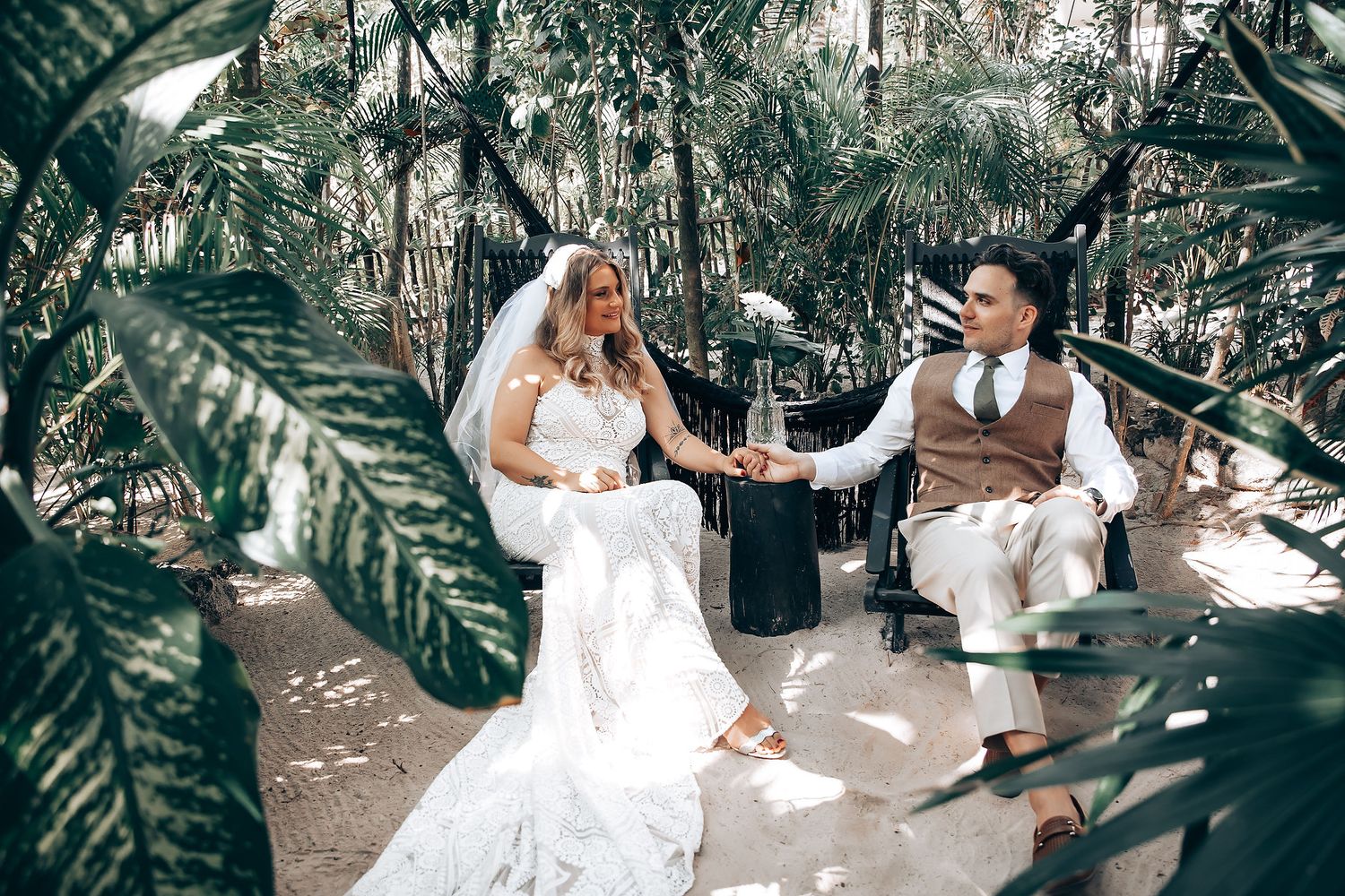 Wedding photoshoot featuring playful moments in a tropical garden landscape.