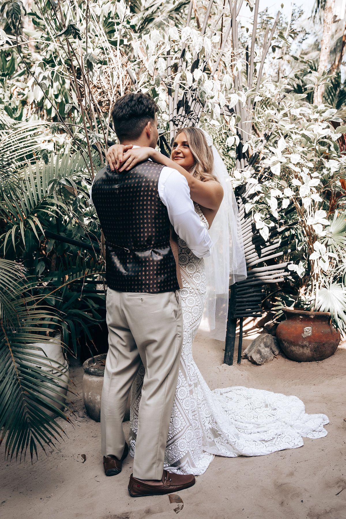 A romantic moment captured in sequence showing a couple dancing together surrounded by tropical plants and white flowers.