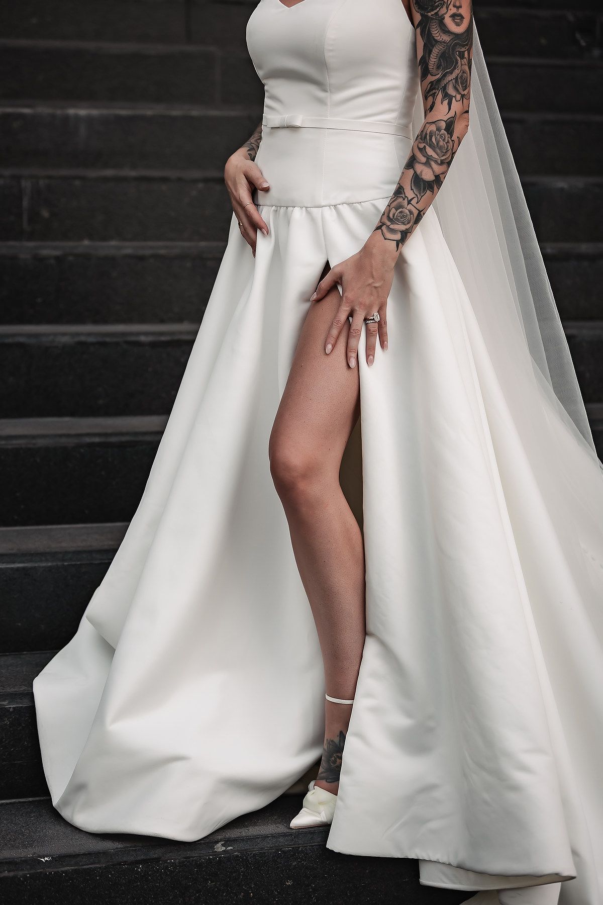 Artistic black and white shots showcasing details of a modern white wedding dress with leg slit.