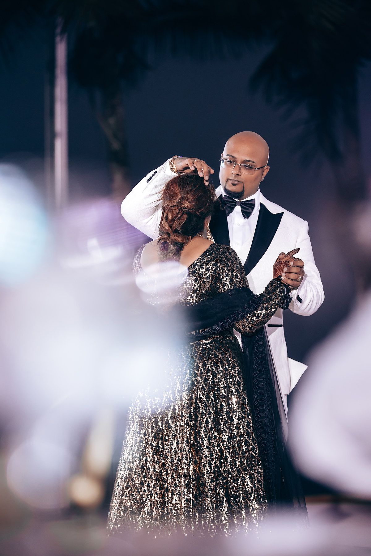 Elegant dance sequence captured at a formal event with sparkling chandeliers overhead.