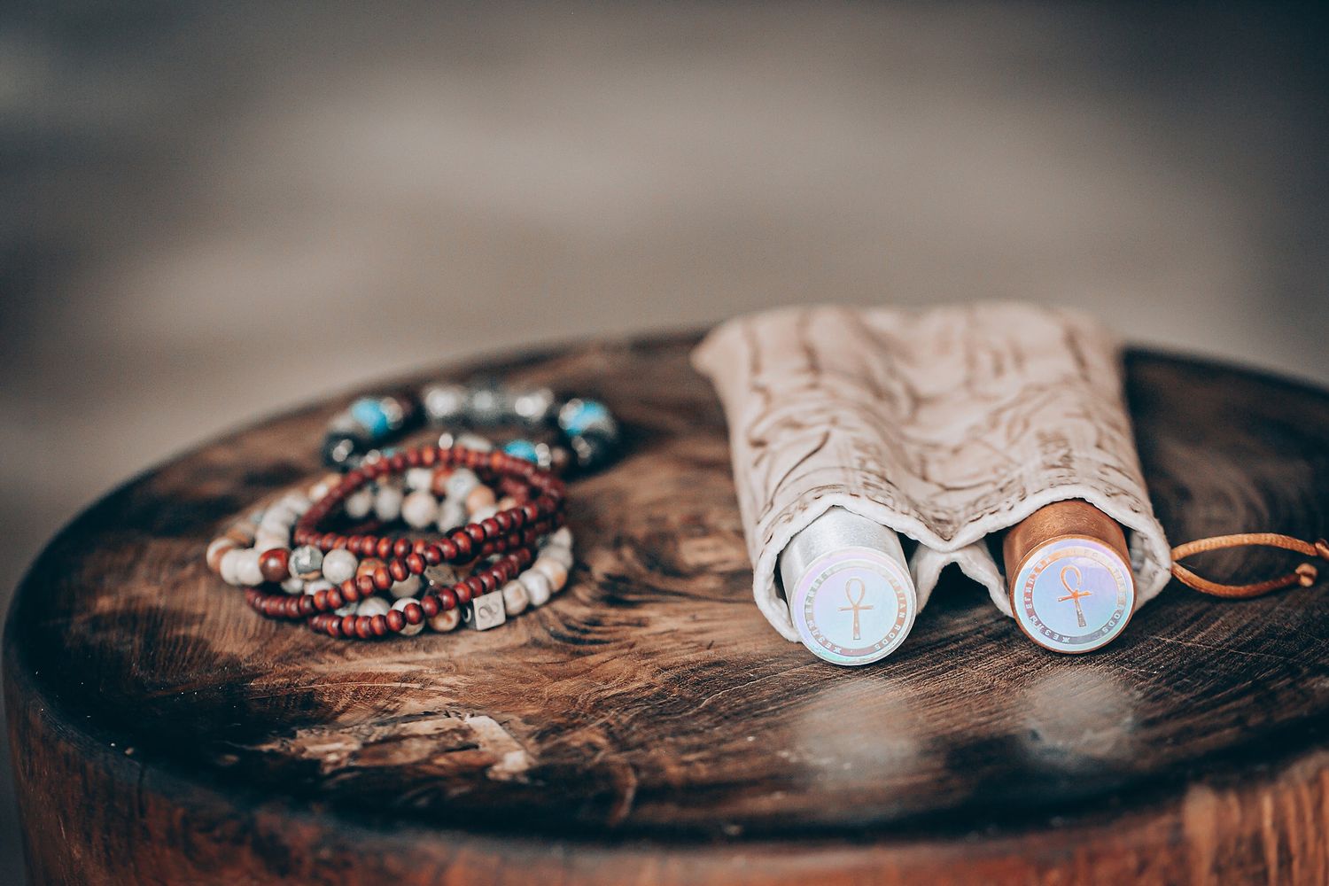 Various jewelry pieces and accessories displayed on a rustic wooden surface with a dark moody aesthetic.