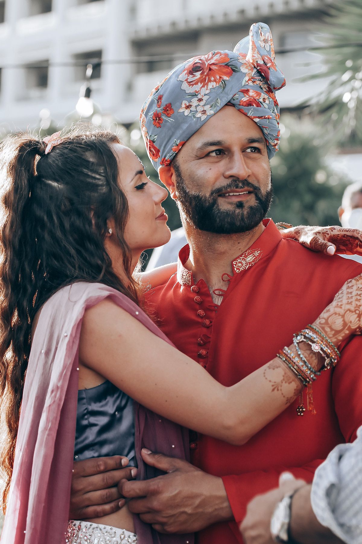 Emotional moments shared between people wearing traditional red attire during cultural celebration.