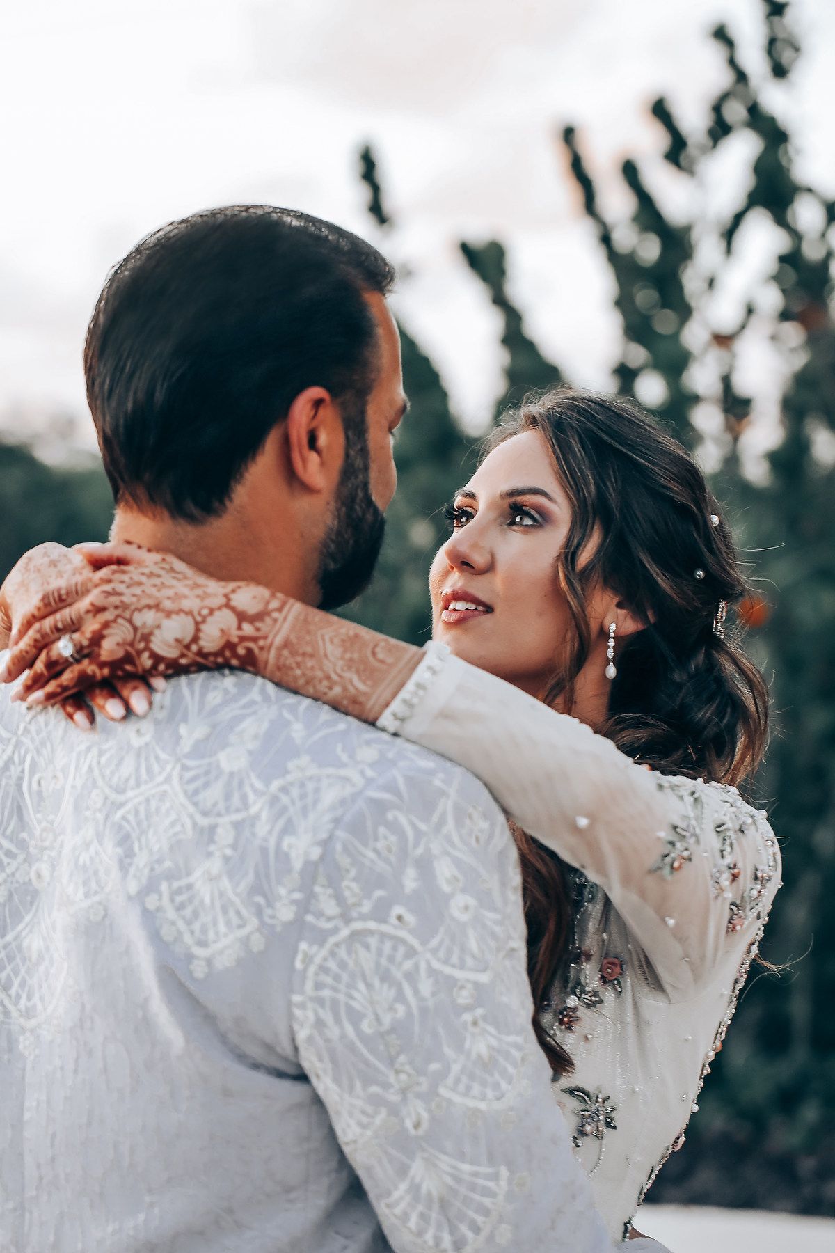 A romantic wedding photo sequence showing close-up shots of a couple embracing in their white lace wedding attire.