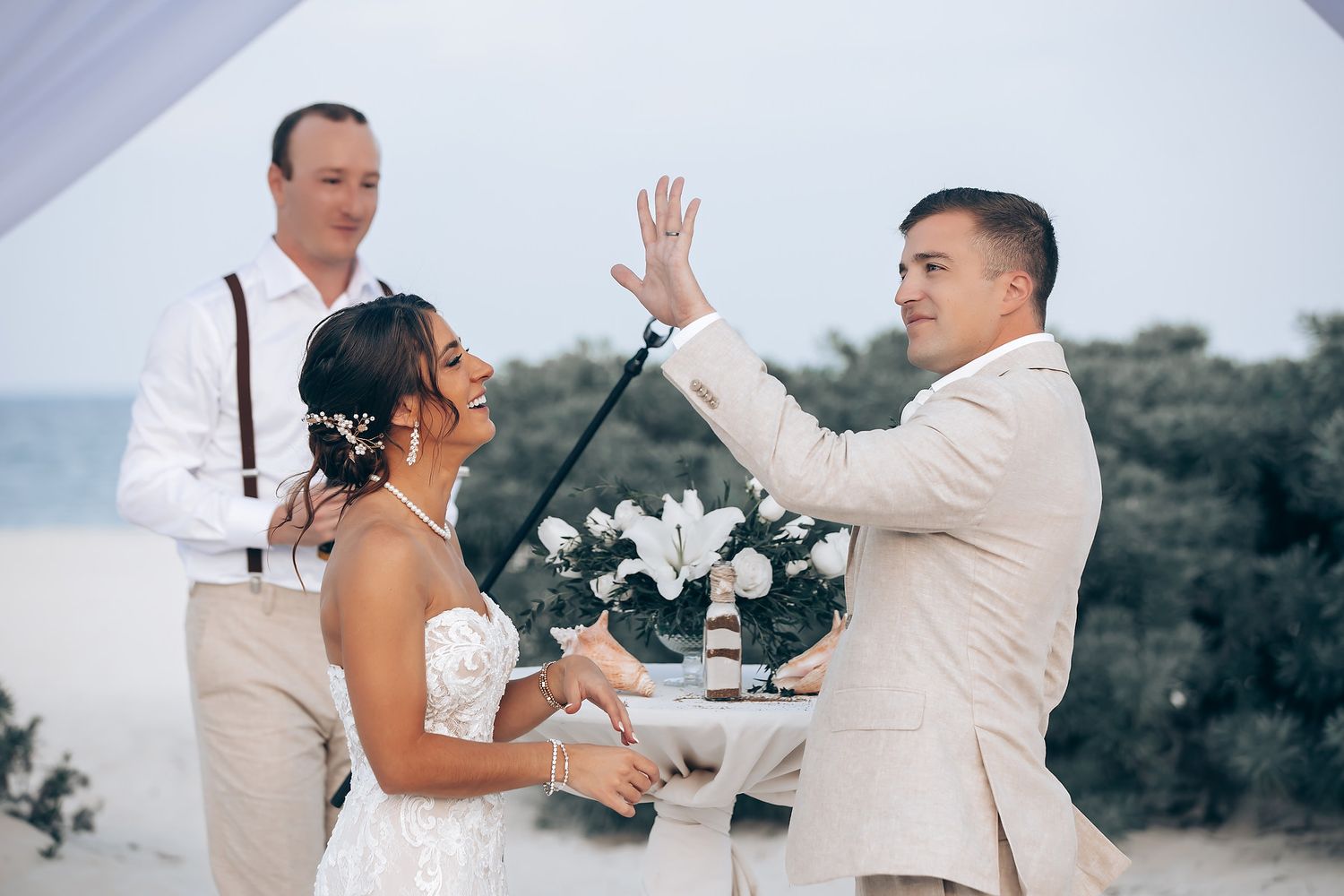 Couple exchanging rings during their beachfront wedding ceremony.