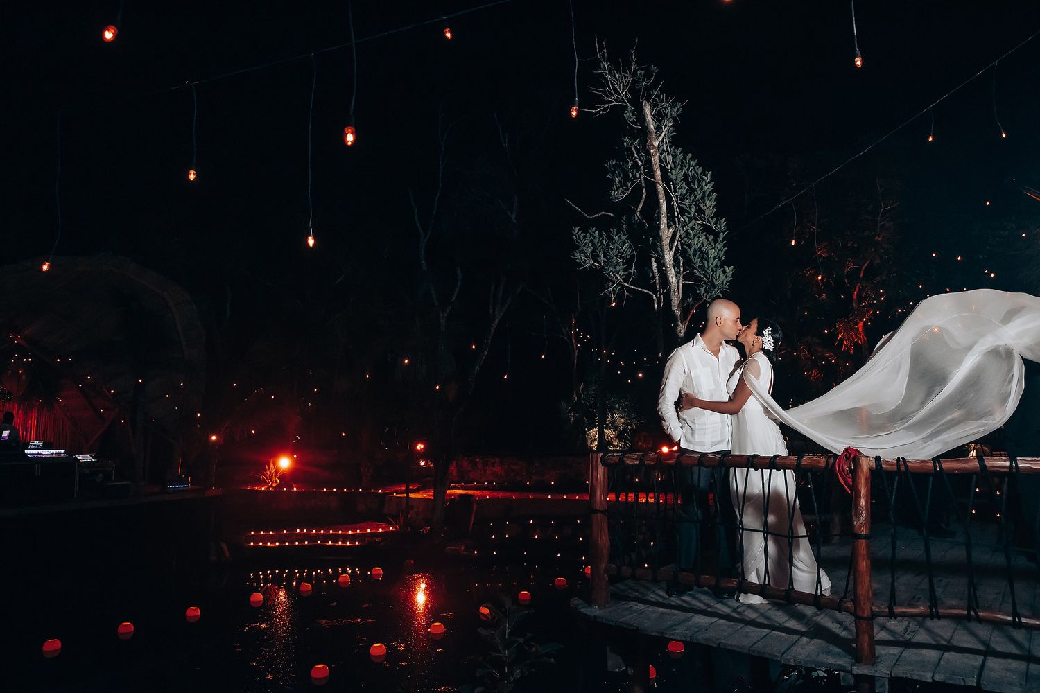 Romantic nighttime celebration with string lights and white fabric decorations.