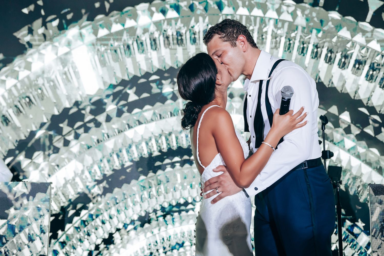 Couple sharing an intimate dance moment under crystal chandelier lighting.