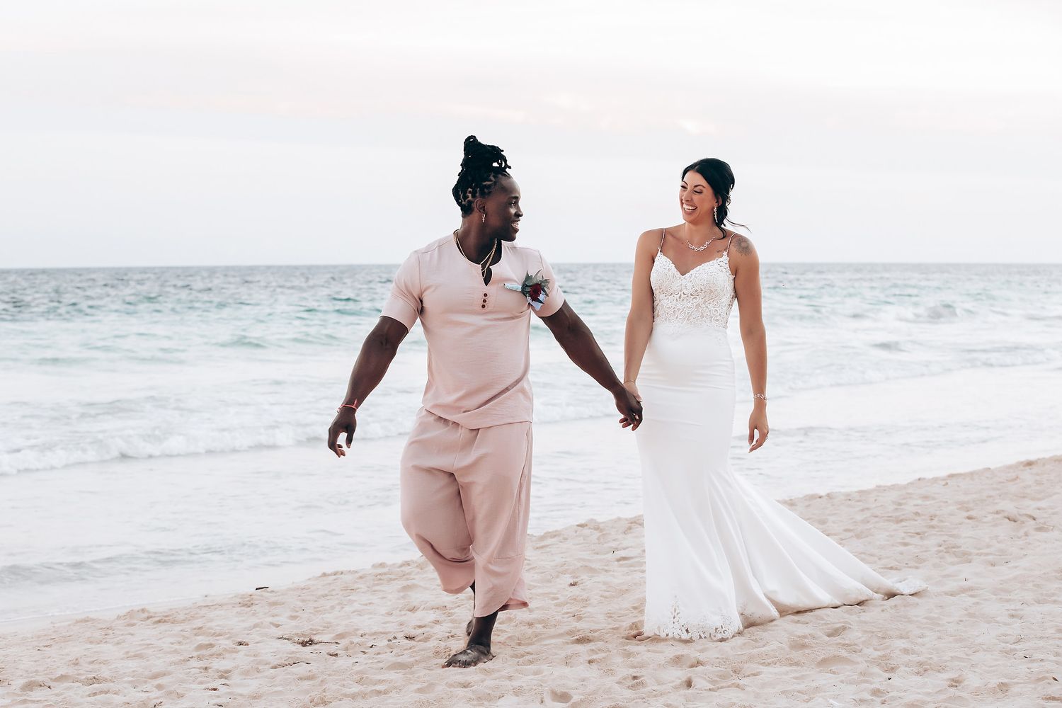 The image shows a group of people performing a traditional dance at a wedding celebration in a tropical setting.
