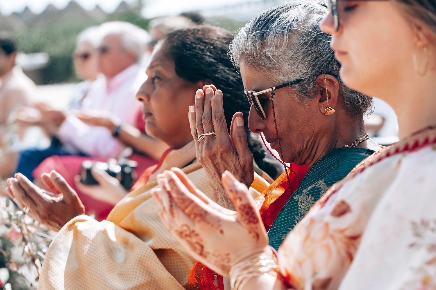 Wedding guests watching the ceremony proceedings at an outdoor venue.
