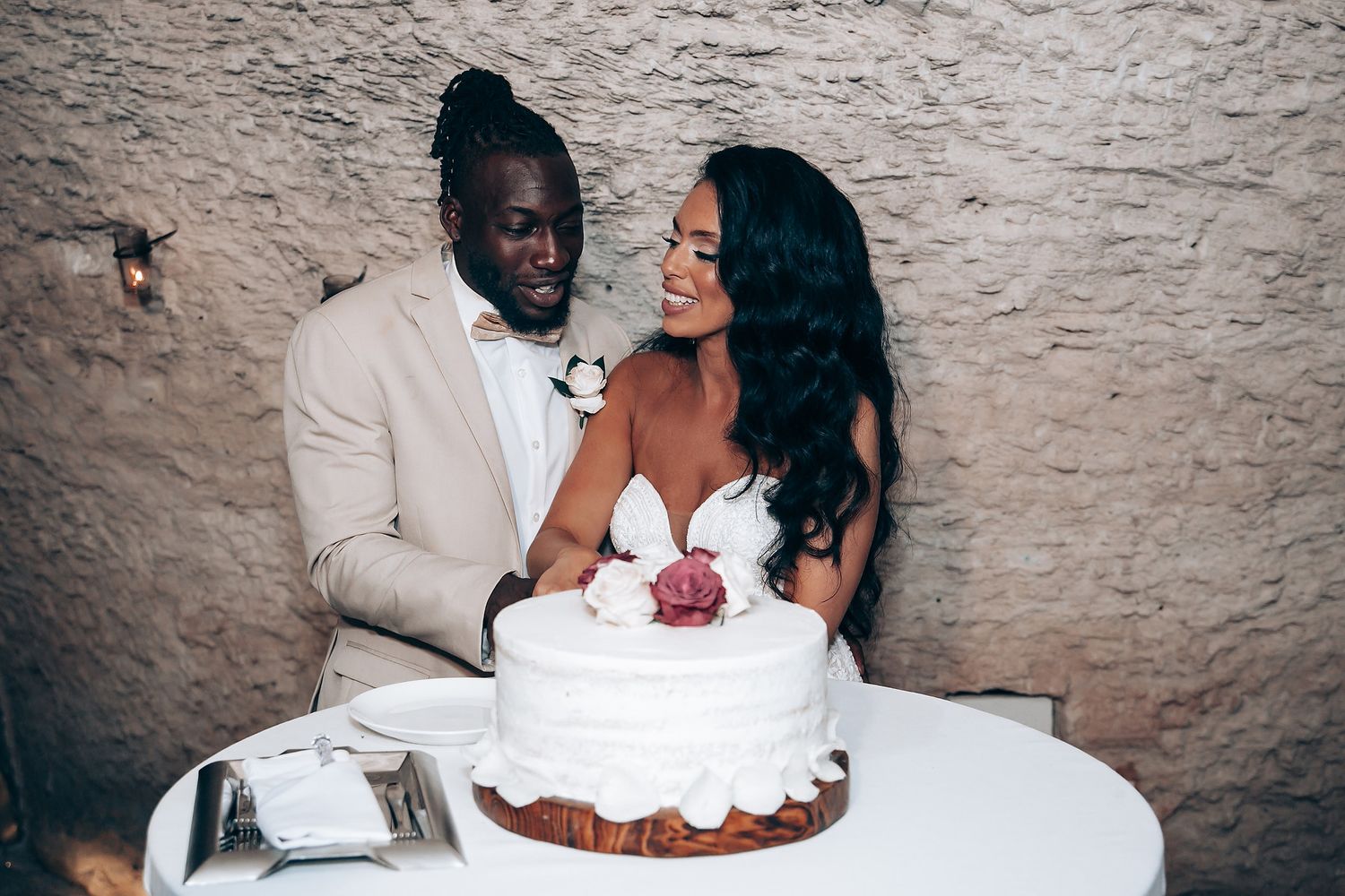 Couple sharing a moment together near their white wedding cake.