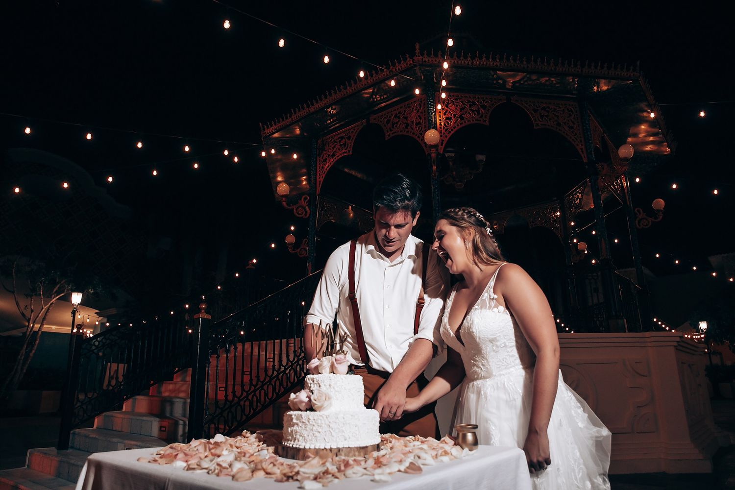 Wedding reception at night with string lights creating romantic ambiance.