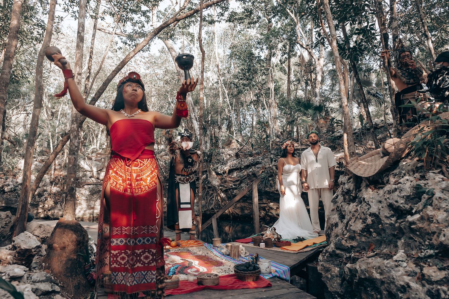 Forest wedding reception with guests dancing and celebrating among trees and natural decor.