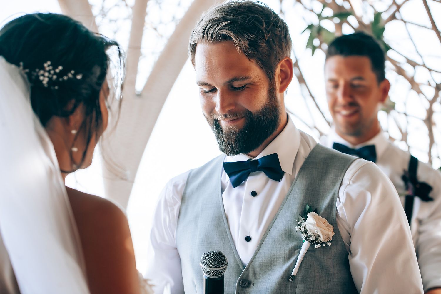Wedding party members in formal attire stand together during the ceremony.