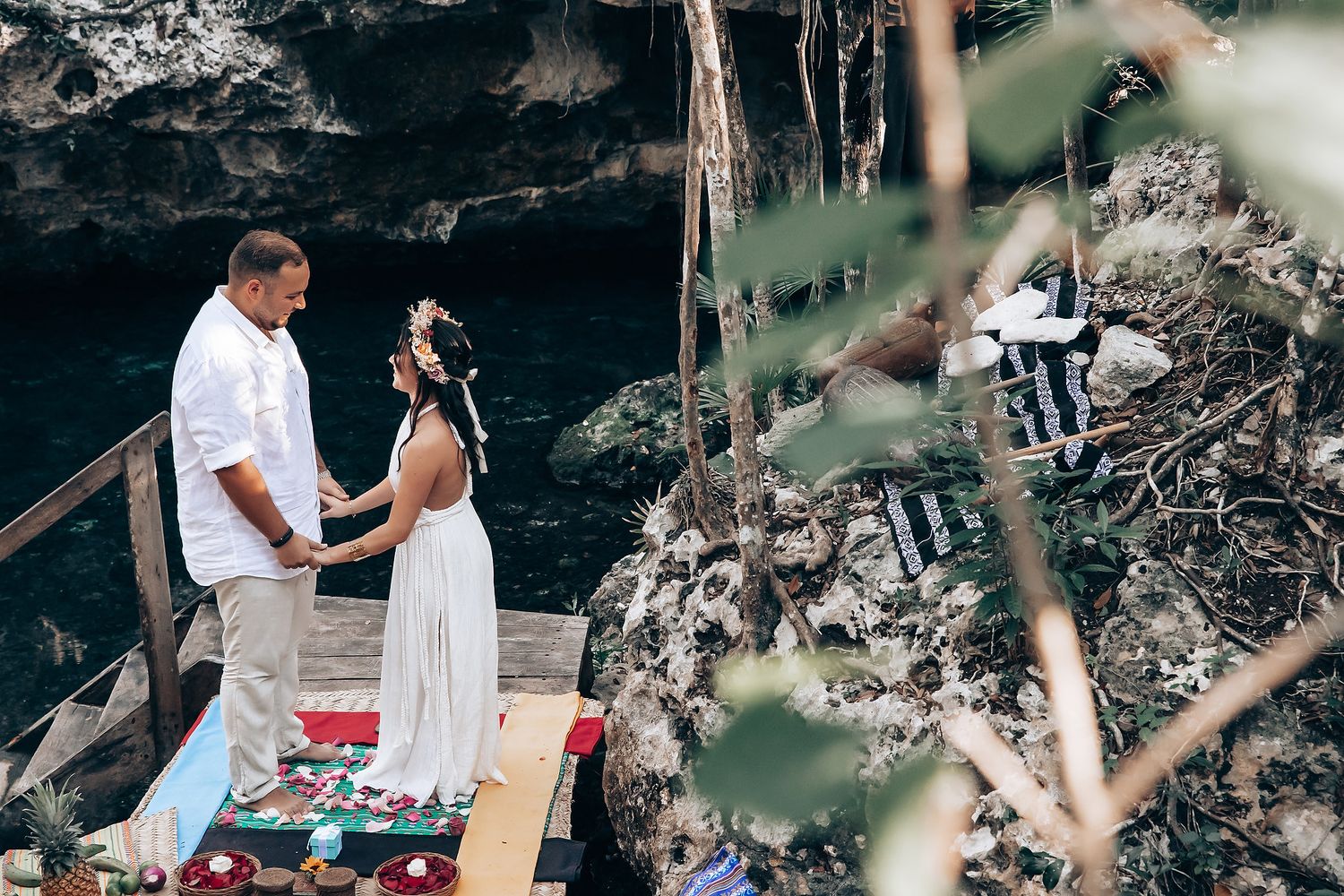 A romantic outdoor ceremony in a wooded setting with a couple exchanging vows.