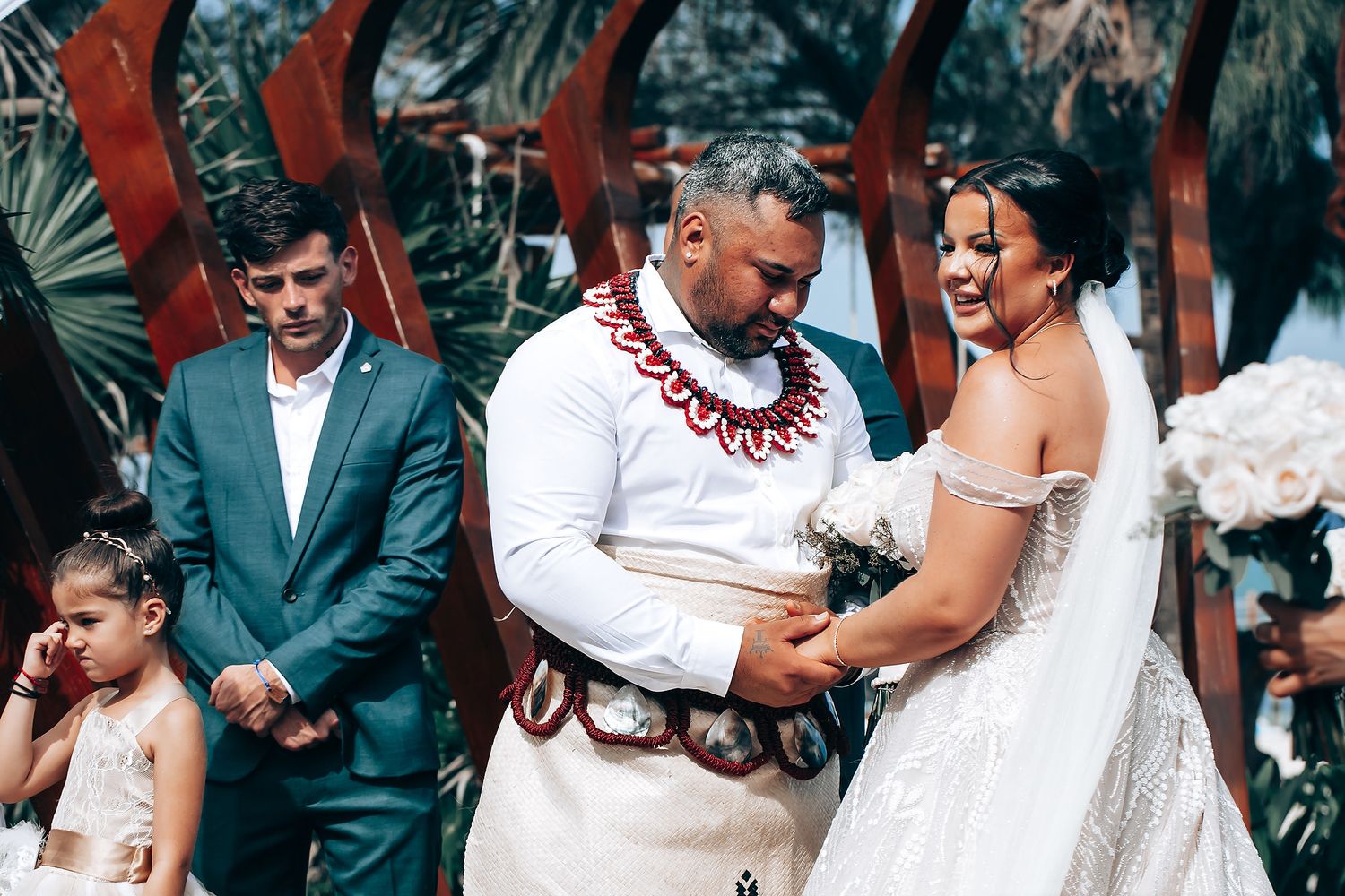 Wedding ceremony moments captured under a tropical outdoor setting.