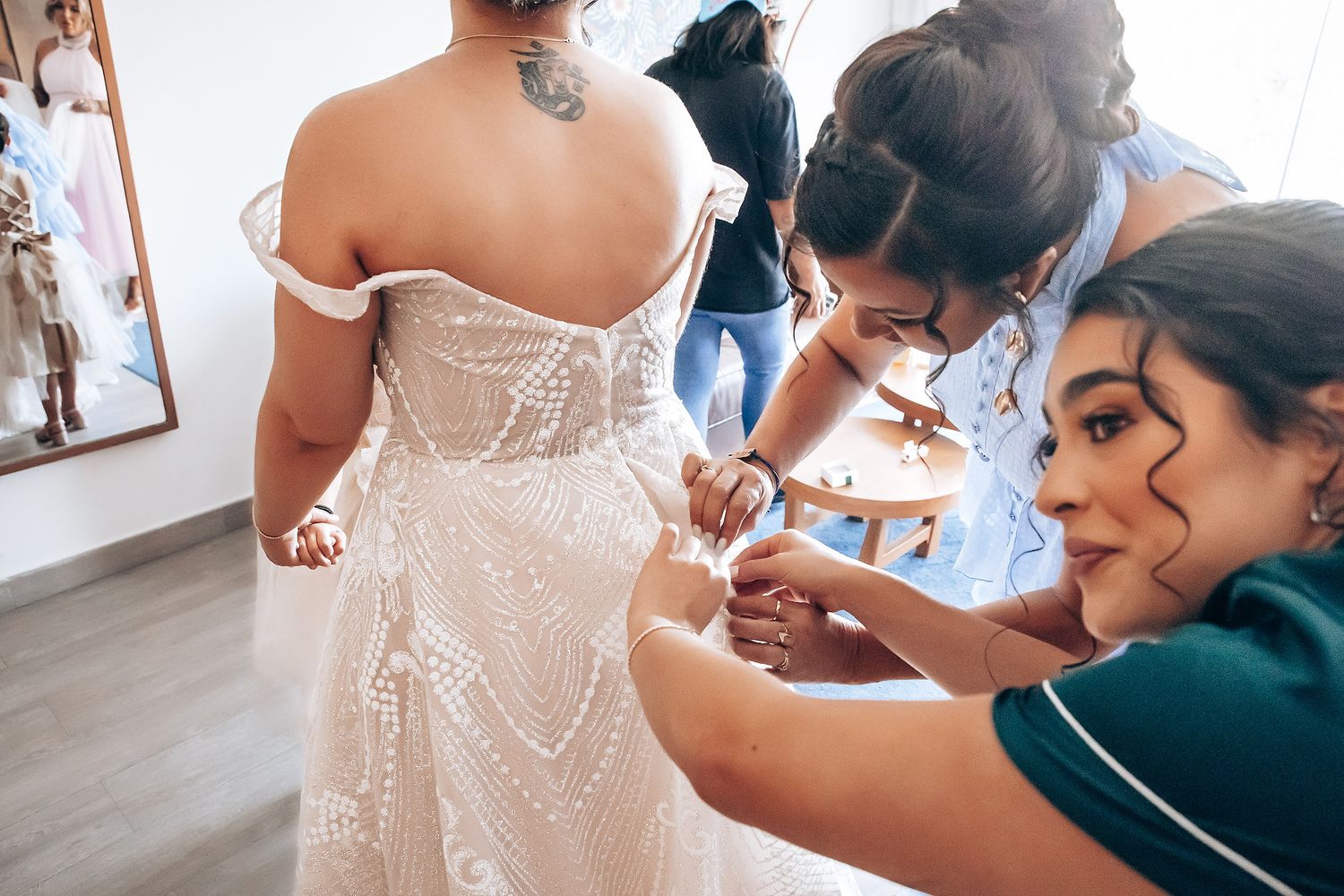 Professional makeup artist applies finishing touches to bride's wedding day look in elegant white gown.