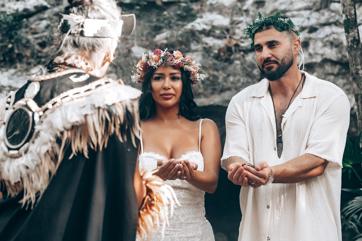 A traditional wedding ceremony unfolds against a rocky backdrop with ceremonial elements.