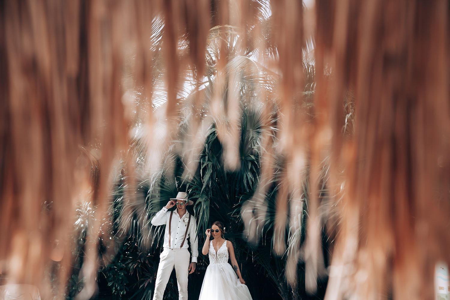 A couple shares an intimate moment during their wedding photoshoot in a dreamy forest setting.