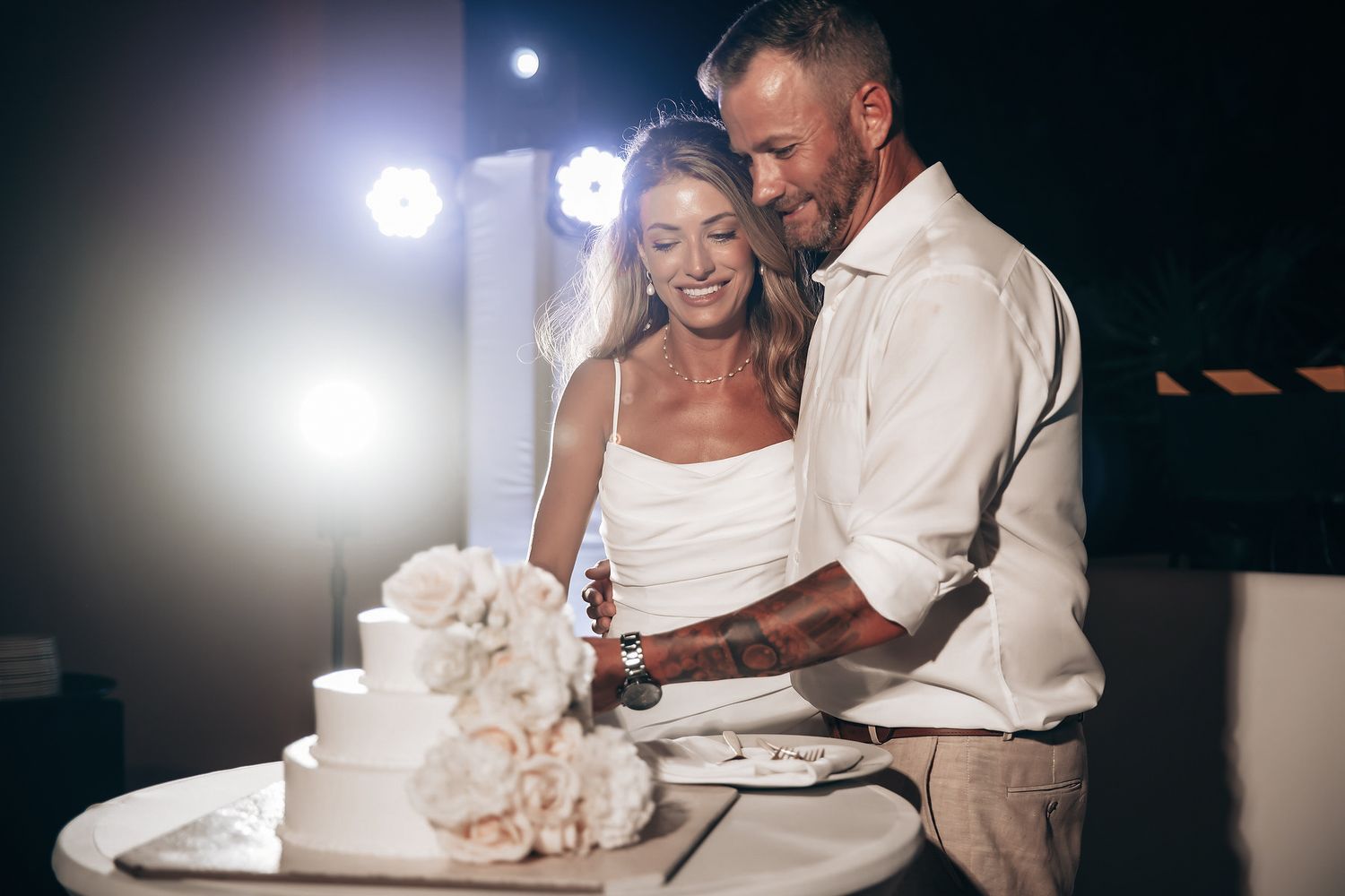 A bride and groom cutting their wedding cake together at their reception.