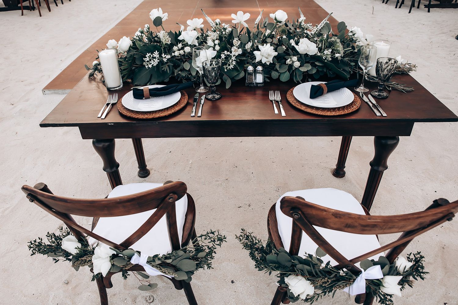 Elegant wedding reception table settings with black and white decor and floral arrangements.