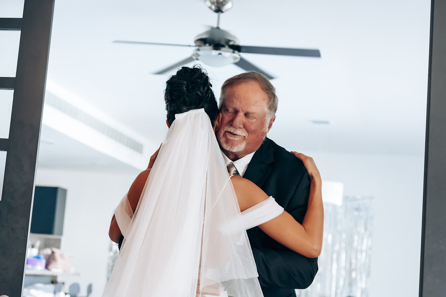 Wedding celebration with white decor and hanging crystal elements.