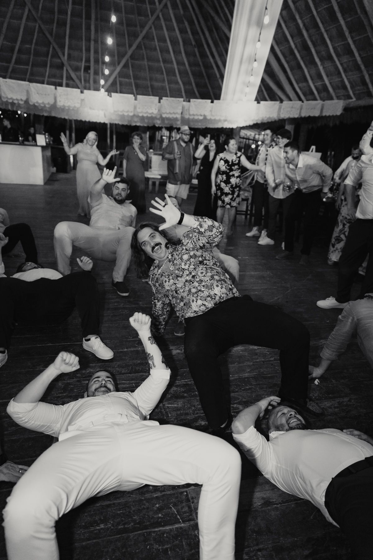 Wedding guests energetically dancing and celebrating on the dance floor at reception party.